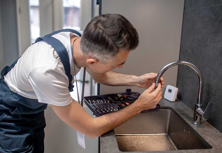 Man spinning faucet aerator on spout pipe